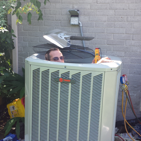 Reliable J.Tullos Service technician servicing an air conditioning unit in Pearland, TX for optimal efficiency