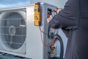 Experienced HVAC contractor checking refrigerant levels and airflow with professional diagnostic tools