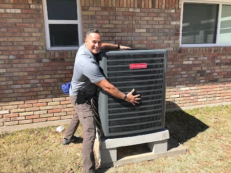 J. Tullos technician setting a new Goodman condenser on a raised pad near Dickinson, TX