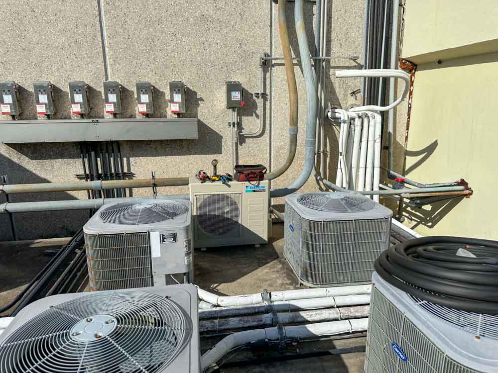 Technician restoring cool airflow from outdoor AC unit at Baytown family home